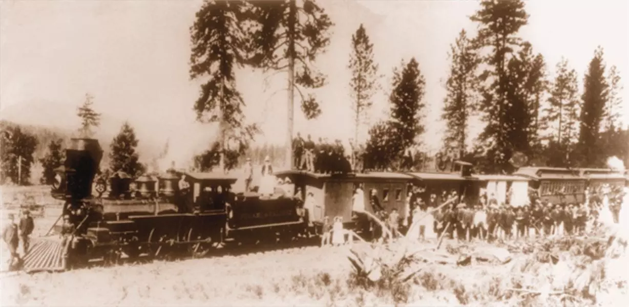 People standing around train circa 1887