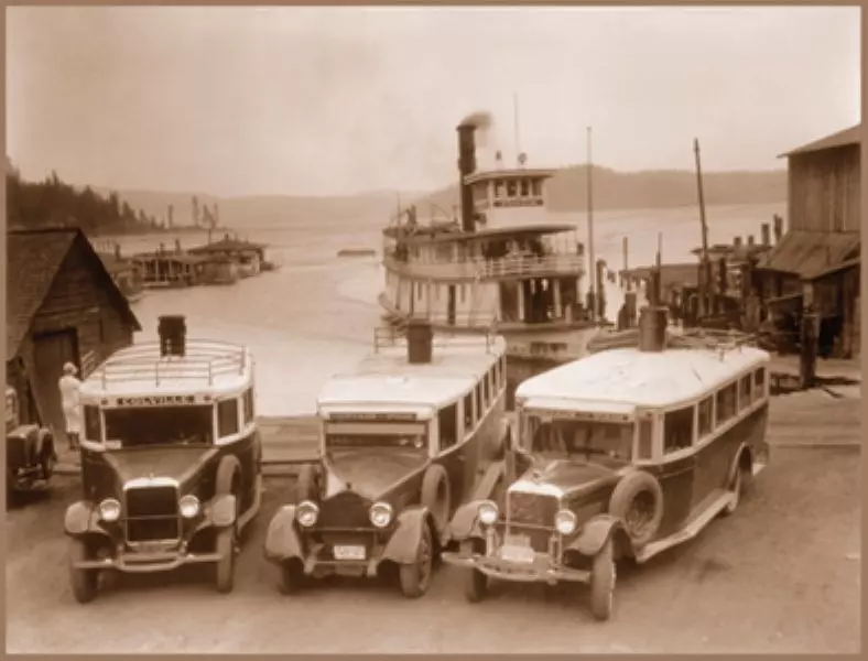 Steamboat meeting 3 busses at a dock circa 1920