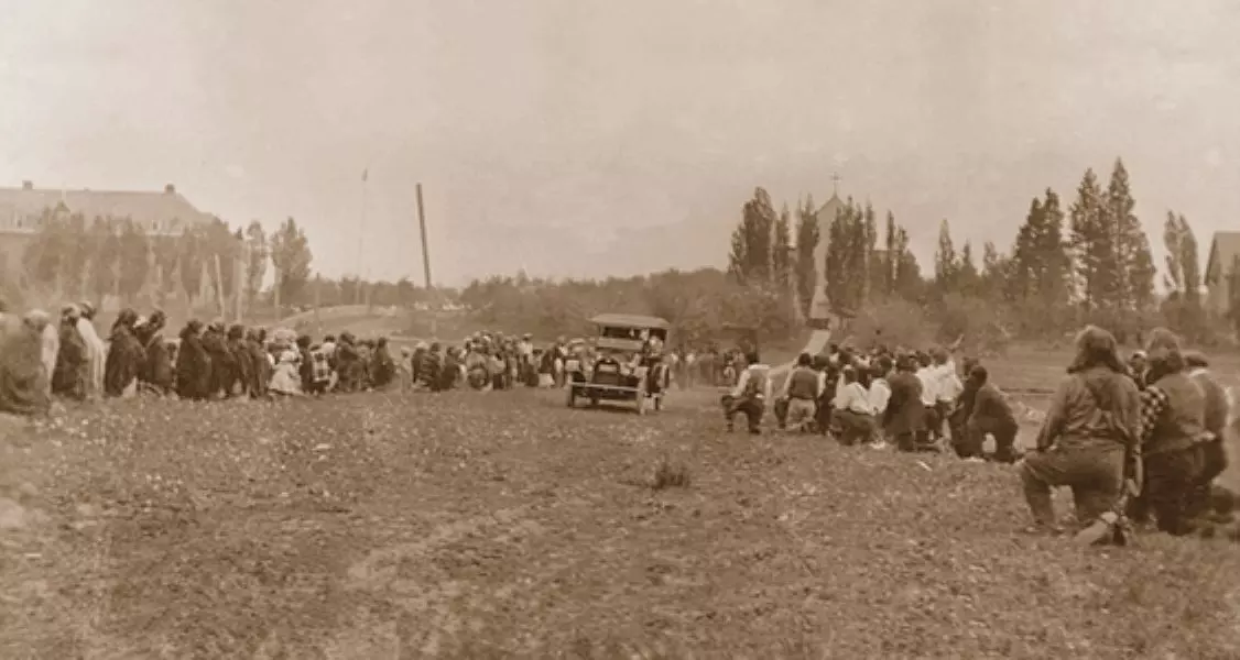 Tribe crowd kneeling and an automobile