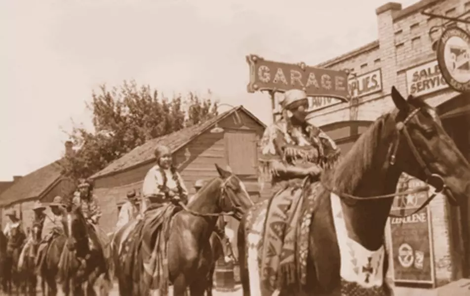 Tribe on horseback riding down street